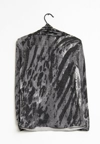 Haut à manches longues imprimé animal gris avec un éclat métallique, doté d'un col drapé et d'une texture douce, accroché à un crochet noir.