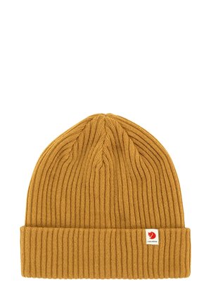Mosterdgele gebreide beanie met een geribbelde textuur en opgerolde rand. Heeft een klein rood-wit merkembleem aan de zijkant.
