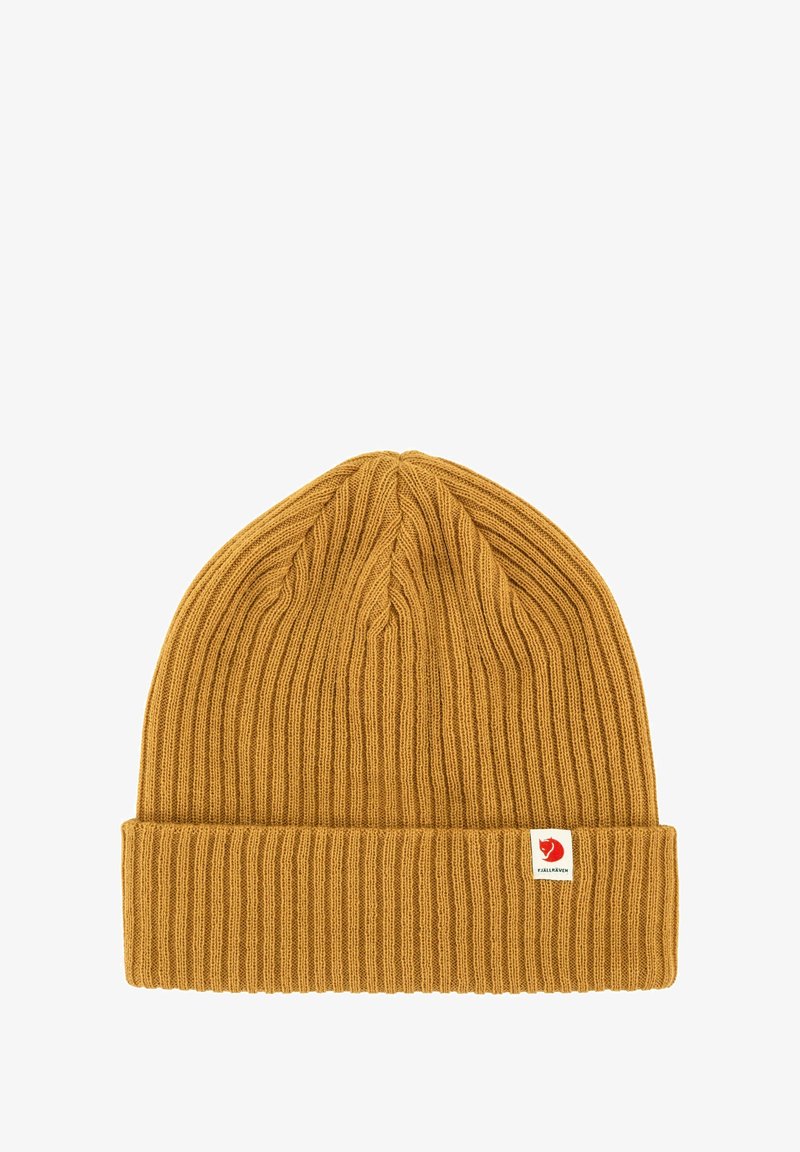 Mustard yellow knit beanie with a ribbed texture and folded cuff. Features a small red and white brand logo tag on the side.