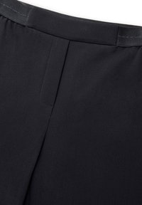 Zwarte stretchbroek met een vlakke voorkant, een soepele textuur en subtiele stikdetails bij de taille.