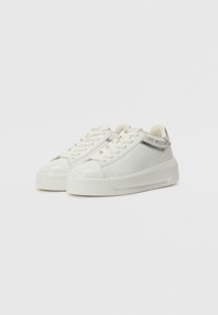 Sneakers bianchi con tomaia in pelle liscia, punta arrotondata, lacci piatti e stampa del logo sul lato. Suola spessa per un migliore ammortizzamento e supporto.