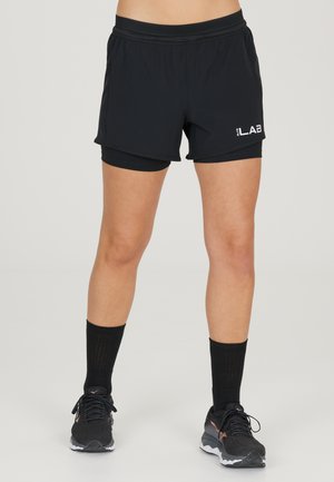 Sorte atletiske shorts med en bred talje, let udsvinget design og inderside, der har et hvidt logo på siden.