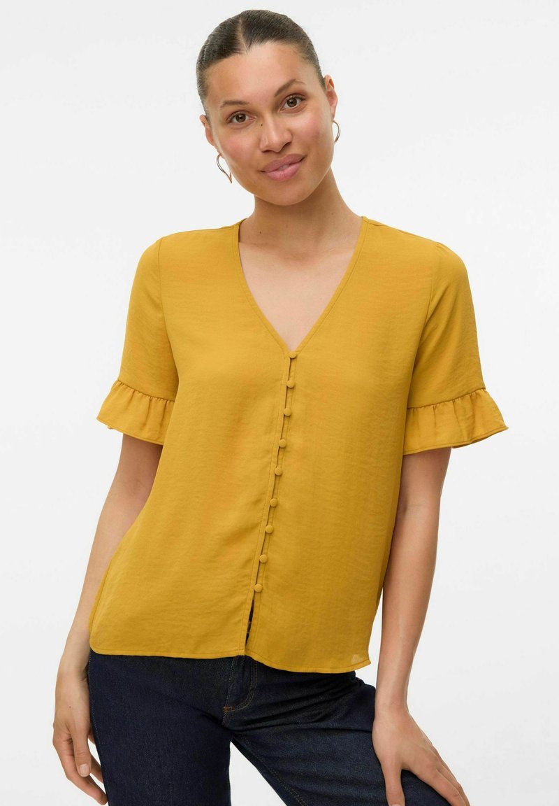 Blusa a maniche corte giallo senape con scollatura a V, caratterizzata da un davanti con bottoni, maniche a flusso con rouches e una texture liscia.