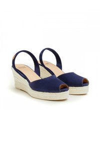 Sandalias de cuña de ante azul marino con punta abierta, tirantes tipo slingback y plantilla de yute trenzado. Destacan por su combinación de texturas y contraste de colores.