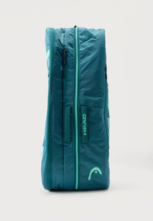 Bolsa deportiva rígida de color verde azulado con dos cremalleras, asa lateral y logo "HEAD" sobre un fondo claro liso.