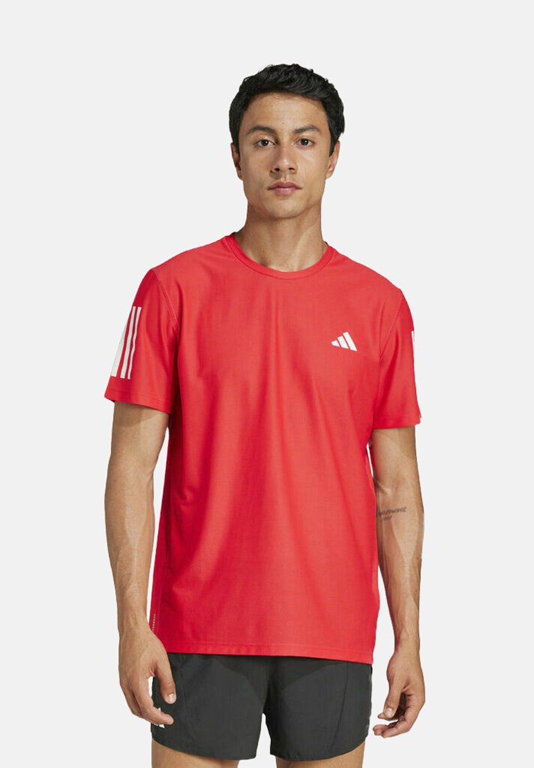 Camiseta deportiva roja hecha de tejido transpirable, con un diseño de tres rayas blancas en las mangas y un pequeño logo en el frente.