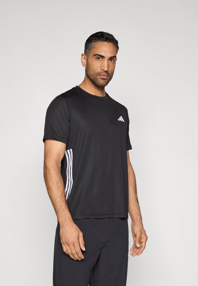 Camiseta deportiva negra con mangas cortas, cuello redondo y tres rayas blancas a lo largo de los costados. Hecha de tela transpirable que absorbe la humedad.