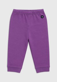 Pantalons de survêtement violets avec une taille élastique, des poignets côtelés, une texture lisse et un petit patch logo noir sur le côté gauche.