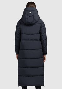 Marineblauer Puffer-Mantel mit Kapuze, horizontal gestepptem Design und Logodetail auf der Rückseite. Langer Schnitt, elastische Ärmelbündchen, seitliche Schlitze.