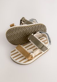 Sandales à brides composées de lanières beige, olive et bleu clair, d'une semelle intérieure rayée et d'une semelle extérieure en caoutchouc texturée.
