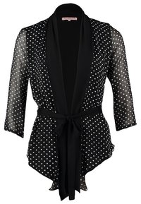Blusa negra translúcida con lunares blancos, mangas 3/4, cuello chal y cinturón de lazada en la cintura.