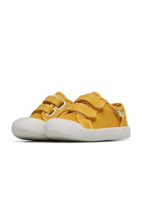 Žluté plátěné boty s bílou gumovou podrážkou, vybavené dvěma suchými zipy na svršku. Kulatá špička a minimalistický design.