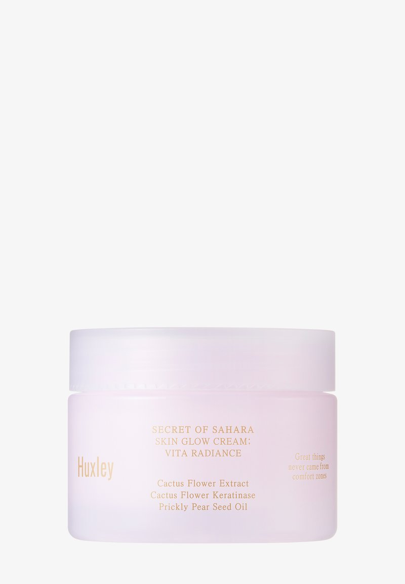 Huxley huidverzorgingscrème in een matte lavendelkleurige jar met een witte deksel. Bevat gouden tekst met details over ingrediënten en de productnaam.