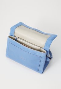 Kék velúrbőr és bőr crossbody táska krém belső résszel, cipzáros rekesszel és elülső zsebbel, strukturált téglalap alakú.