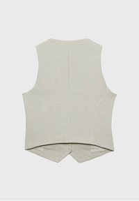 Beige linne ärmlös väst med hög halsringning, sid sömmar och en rundad bakslut. Materialet har en jämn textur med en subtil lyster.