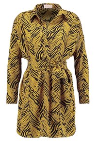 Żółta i czarna sukienka koszulowa w wzór zebra z kołnierzykiem, długimi rękawami i związanym w pasie. Wykonana z gładkiego materiału o luźnym kroju.