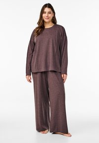 Ensemble de détente en tricot marron comprenant un haut à manches longues et un pantalon à jambes larges. Texture douce, coupe décontractée et motif chiné subtil.