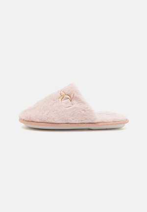 Chausson en peluche rose avec un design à bout pointu, doté d'un détail de boucle dorée et d'un dessus en fourrure texturée. Semelle plate beige.