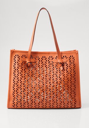 Πορτοκαλί δερμάτινη τσάντα tote με γεωμετρικό μοτίβο κοπής, δύο ανθεκτικές λαβές και ενισχυμένη ραφή κατά μήκος των άκρων.