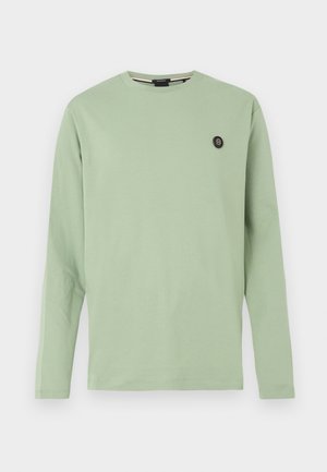 Lysegrøn langærmet t-shirt lavet af blød bomuld. Har rund halsudskæring og en lille sort logo på venstre bryst. Enkel design.