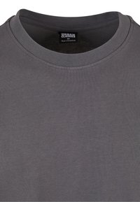 Pelēka kokvilnas T-kreklu ar apaļu kakla izgriezumu un īsām piedurknēm. Audumam ir gluda tekstūra. Etiķete norāda "Urban Classics", izmērs M.