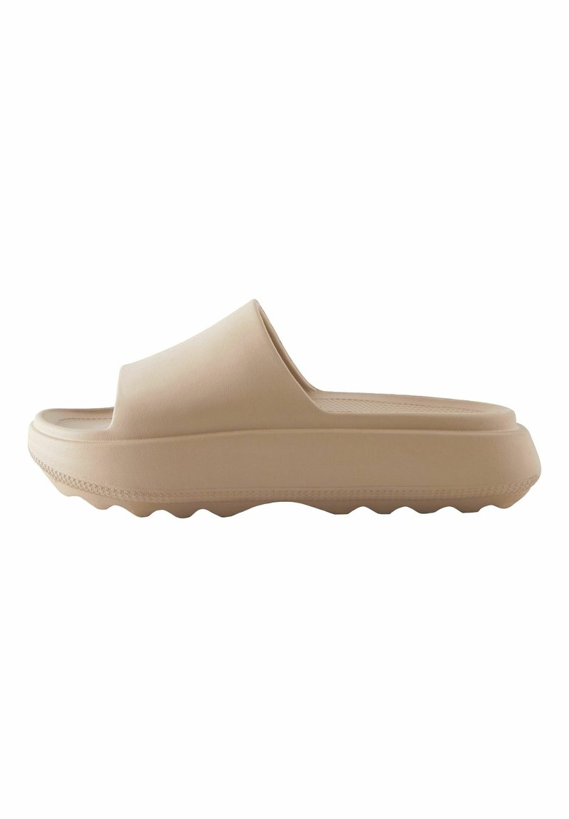Sandales à glissière beiges en caoutchouc lisse, avec une large bride, une semelle intérieure profilée et une semelle épaisse et ondulée pour une meilleure adhérence.