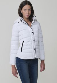 Chaqueta blanca acolchada con capucha, ribete negro y botones a presión. Presenta bolsillos laterales con cremallera y un collar suave y texturizado.