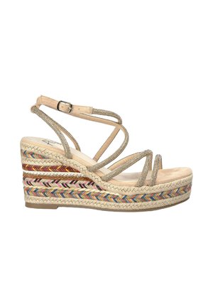 Sandalia de cuña con suela de yute trenzado, presenta correas metálicas doradas y un patrón trenzado multicolor en la cuña. Hebilla ajustable en el tobillo.