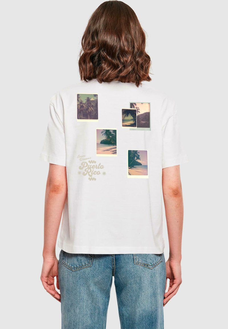 Witte katoenen t-shirt met een recht model, voorzien van meerdere grafische afbeeldingen van palmbomen en een zonsondergang, plus de tekst "Puerto Rico" in het geel.
