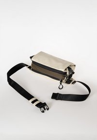 Borsa beige con cerniere nere, una tracolla regolabile e una tasca frontale grigia. Realizzata in materiale resistente con una texture liscia.