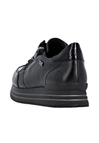 Black leather sneaker with a smooth finish, decorative zip closure, textured accents, and rubber sole featuring contrasting stripes.
