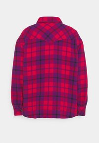 Röd och lila rutmönstrad skjorta med lång ärm, svarta linjer, knappade ärmslut och vikbar krage, visad bakifrån mot en vit bakgrund.