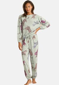 Világosszürke loungewear szett, színes leopárdmintával. Hosszúujjú felsőt és azonos színű, rugalmas derékkal ellátott nadrágot tartalmaz.