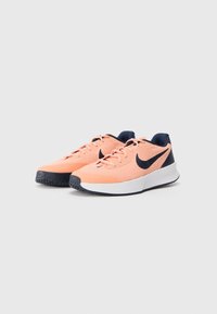 Nike tenisice za trčanje s gornjim dijelom u svijetlos coral boji, mornarskim akcentima, teksturiranim mrežastim materijalom, bijelom srednjom potplatom i crnim gumenenim potplatom.