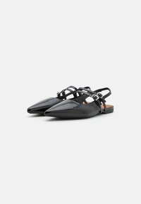 Black patent leather slingback flats with pointed toes, multiple crisscross straps, and adjustable buckles. Flat heel and smooth texture.
