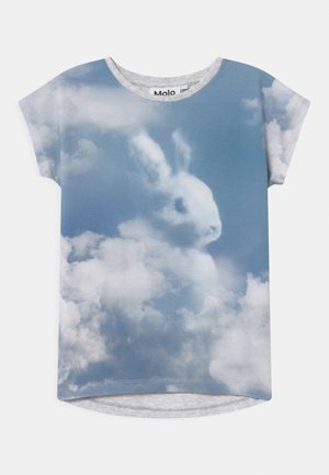 Chemise à manches courtes bleue et blanche avec un motif de nuages formant la silhouette d'un lapin sur un fond de ciel.