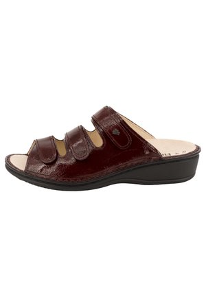 Sandalo aperto in pelle marrone scuro con tre cinturini regolabili e suola nera bassa, progettato per un comfort casual.