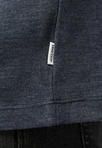 Mørkeblå bomulds T-shirt med et lille hvidt mærke med "JACK & JONES" tekst ved kanten, med en glat overflade og klassisk pasform.
