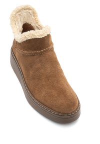 Barna velúr bokacsizma puha, bézs műszőrmével bélelve, kerek orral és texturált gumitalppal, amelyen varrott díszítések találhatók.