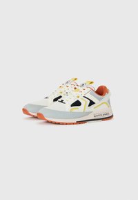Pair of low-top sneakers with white, black, yellow, gray, and orange accents, featuring laces and "Scotch & Soda" branding on the sole.