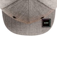Grå caps med flat skjerm, laget av teksturert stoff. Har en svart etikett med "MSTRDS"-logoen i nedre høyre hjørne.