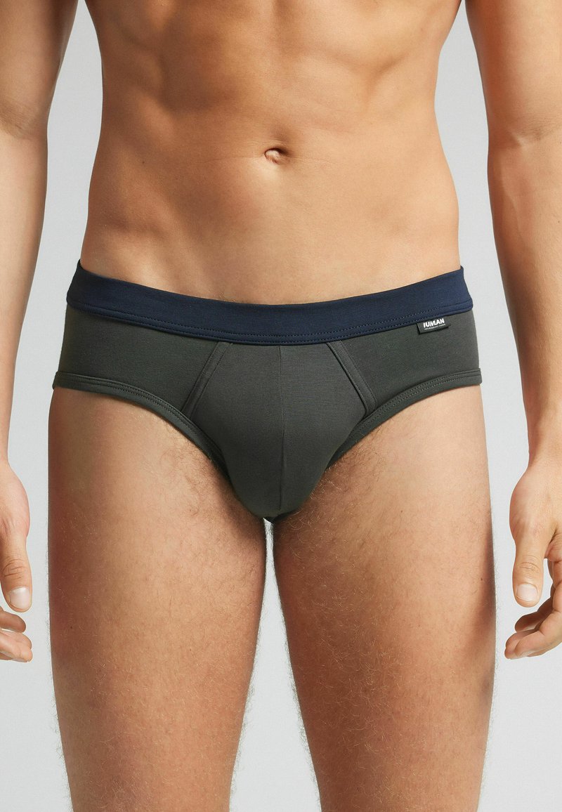 Donker groene slips met een marineblauwe tailleband; heeft een soepele, aansluitende pasvorm en een zachte textuur, geschikt voor dagelijks gebruik.