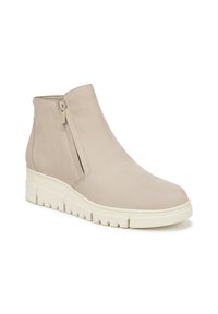 Stivaletto beige con tomaia in pelle liscia, zip laterale e suola in gomma bianca spessa con un motivo di grip testurizzato.