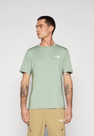 Camiseta verde de manga corta hecha de tejido ligero, con un logo en el lado izquierdo del pecho y paneles laterales texturizados en contraste.