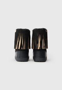 Melnu potīšu pāris ar frinda detaļām ap augšējo malu, redzams no aizmugures uz vienkārša balta fona.