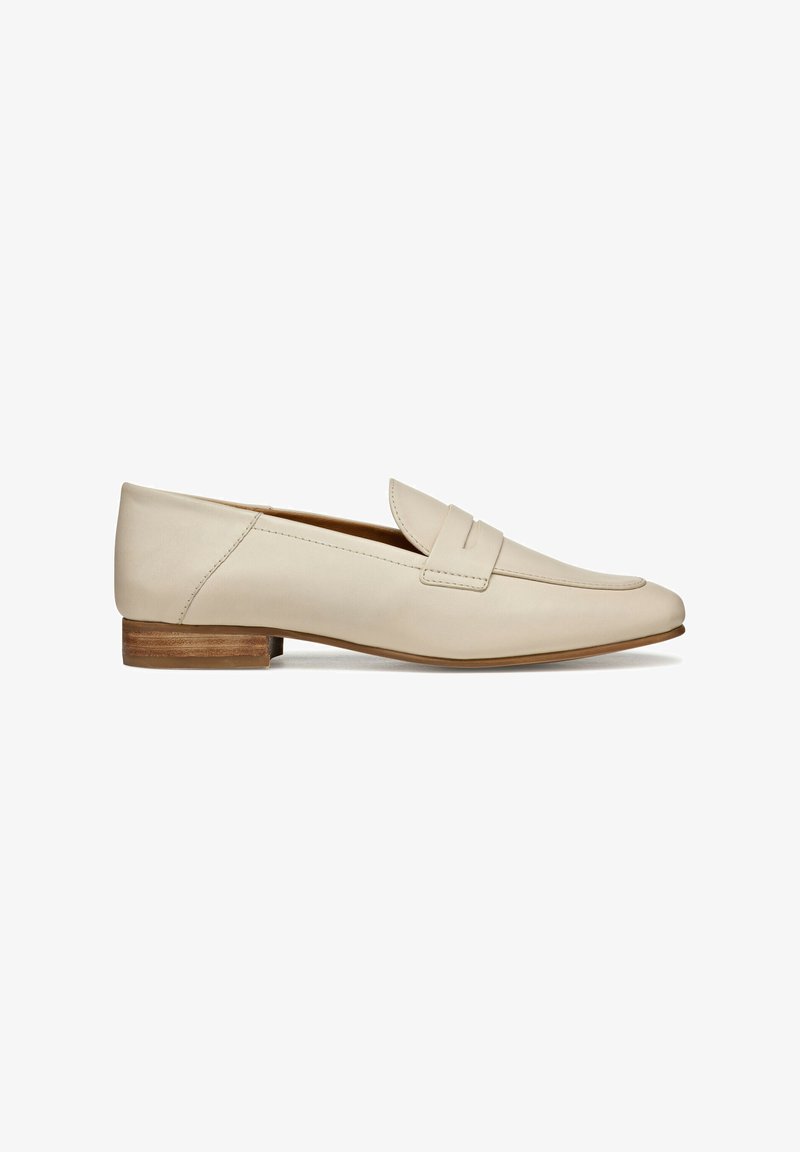 Mocassins en cuir beige avec un design à bout pointu, présentant un détail de sangle cousue et un petit talon en bois. Texture lisse sur l'ensemble.