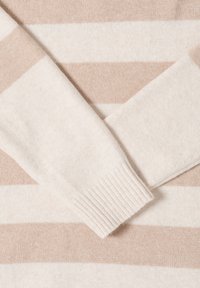 Pull beige clair à rayures horizontales en crème doux et taupe. Le matériau est un tricot doux avec des poignets côtelés et une texture lisse.