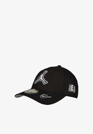 Gorra de béisbol negra hecha de tela, con un logo Jumpman en blanco, acento "AIR" de Nike, y detalles de campeonato bordados en el lado.