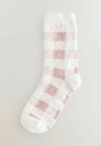 Lämpimät valkoiset sukat, joissa on vaaleanpunainen ruutukuosis, pörröinen texture ja pehmeä resori, suunniteltu mukavuutta ja lämpöä varten.