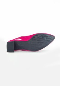 Escarpin en daim rose avec un bout pointu et un design découpé, doté d'une semelle en caoutchouc noir texturé et d'un talon bloc pour plus de stabilité.